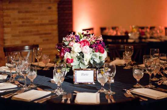 photo of bright wedding centerpieces reception tables themed after travel destinations