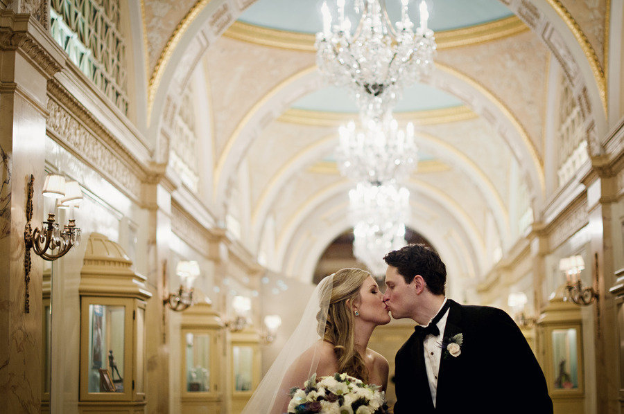 Elegant-wedding-venue-bride-groom-kiss-beneath-chandeliers.full