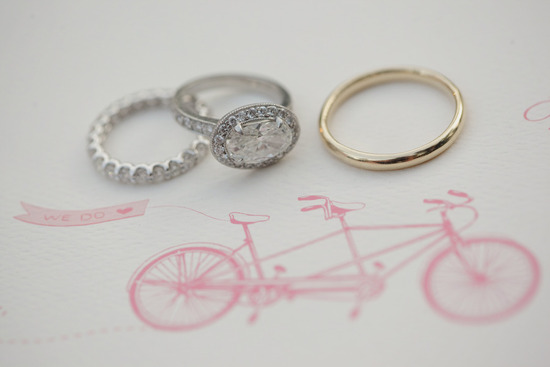 vintage engagement ring with wedding bands atop wedding invitation