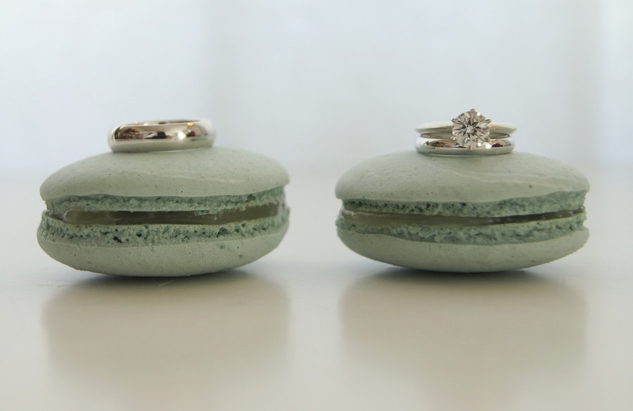 Diamond-engagement-ring-grooms-wedding-band-shot-on-green-macaroons.full
