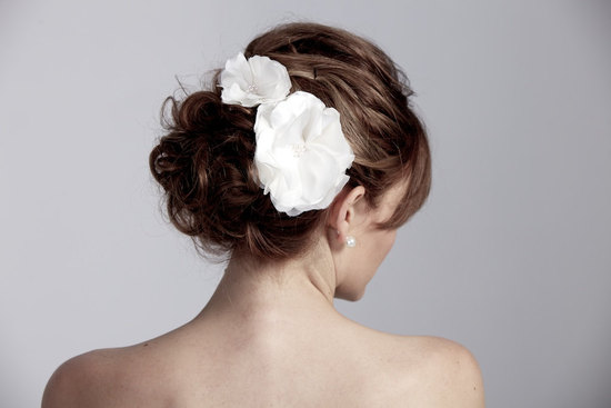 photo of white dual wedding flowers in chic chignon bridal updo